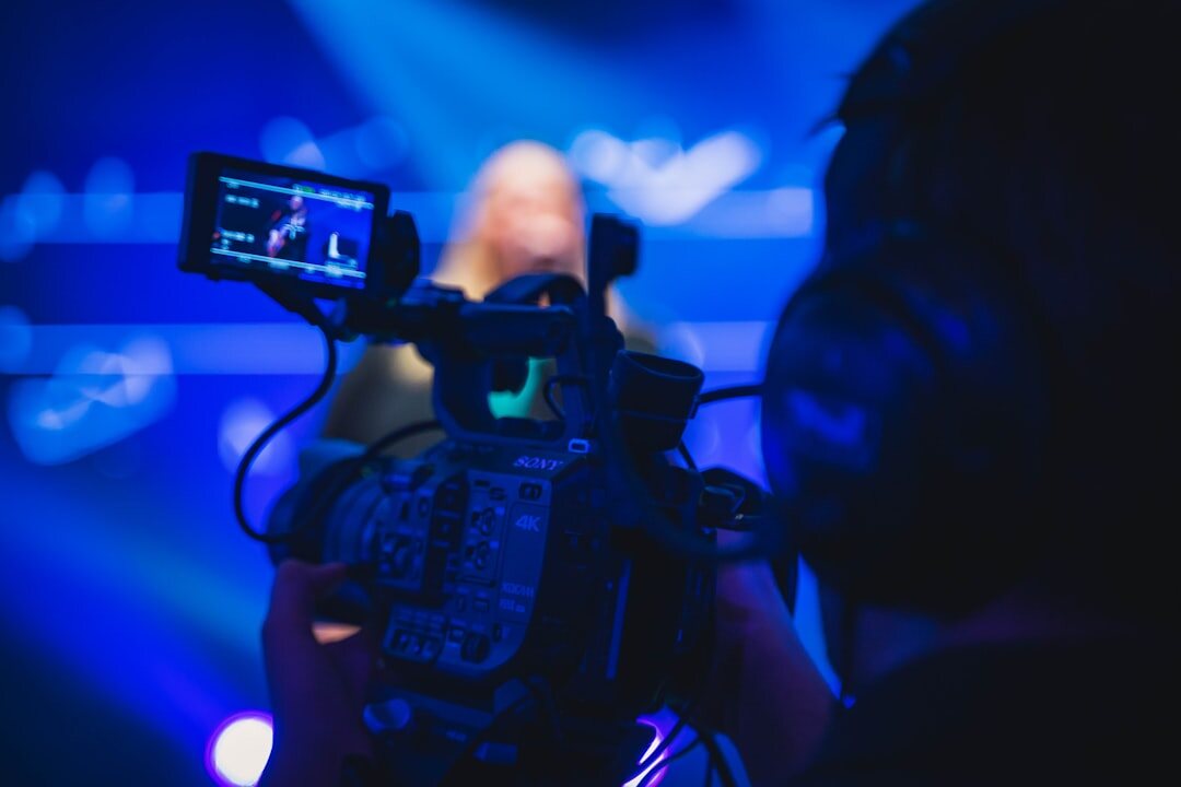 Television camera pointed at a news presenter during a live segment